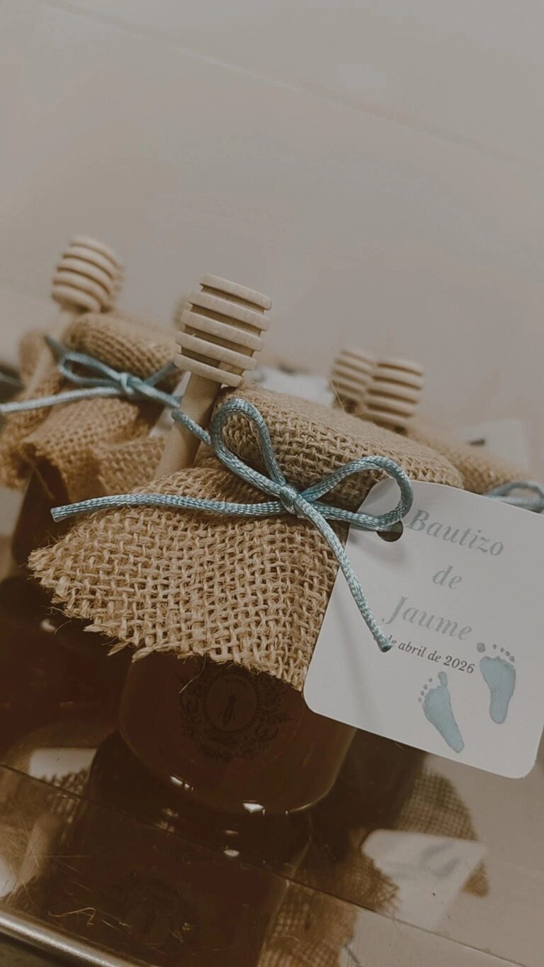 Tarro de miel artesanal Mels La Reineta, envuelto en tela de saco con etiqueta personalizada para el bautizo de Jaume, con cucharita de madera.