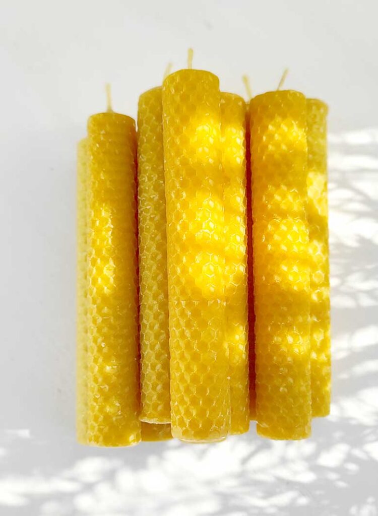 Velas artesanales de cera de abeja natural, creadas por Mels La Reineta, con un hermoso color amarillo y textura de panal.